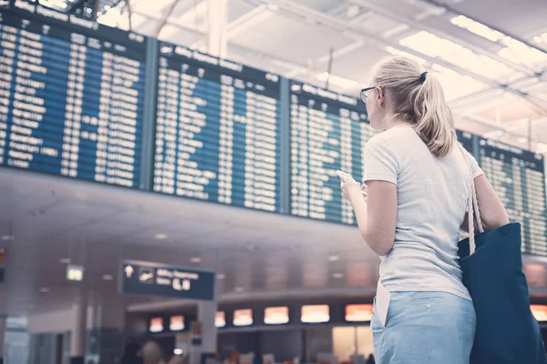 Девушка возле расписания авиакомпаний — стоковое фото