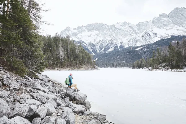 Турист на зимовому гірському озері — стокове фото
