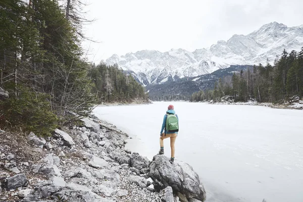 Турист у зимнего горного озера — стоковое фото