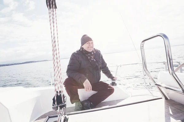 У віці чоловік на вітрильному човні — стокове фото