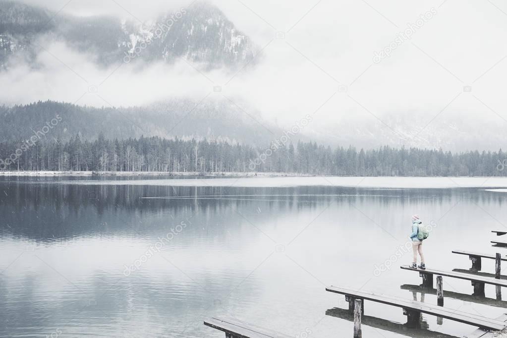 Tourist at winter mountain lake