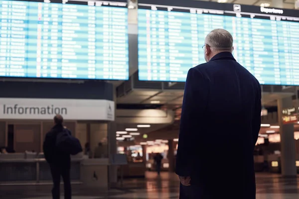 Man near airline schedule — Stock Photo, Image