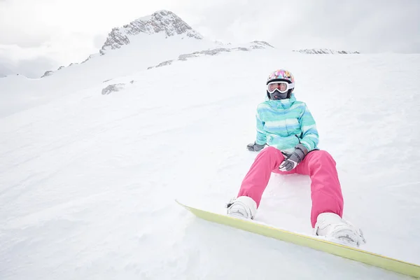 Jovem mulher sentada com snowboard — Fotografia de Stock