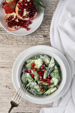 Yoğurt soslu dereotu ve nar taneleriyle taze salatalık salatası.