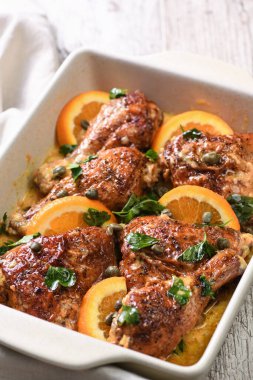 Kremalı soslu fırında tavuk dilimleri, portakallar ve kapari.