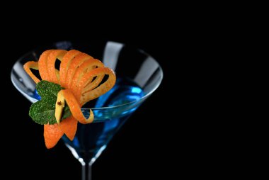 Portakal ve nane kokteyli için dekorasyon. Zarif ve orijinal bir sunum. Siyah arka planda Martini Blue Curacao