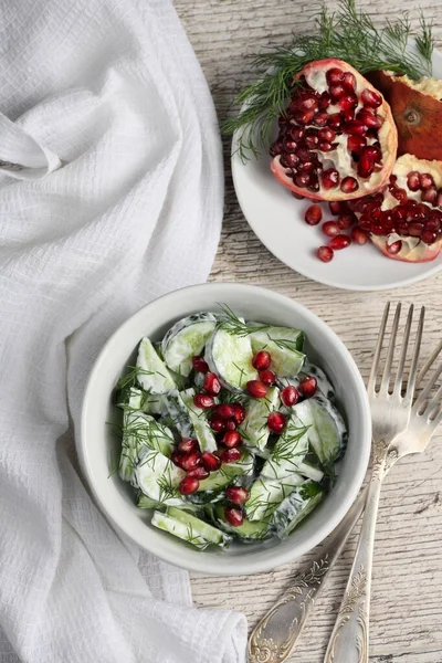 Yoğurt soslu dereotu ve nar taneleriyle taze salatalık salatası.