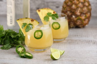Ananas suyu, jalapeno dilimleri ve kişniş ile soğutulmuş tekila kokteyli.