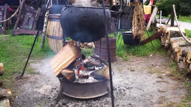 Приготування їжі в таборі в котел над вогнем — стокове відео