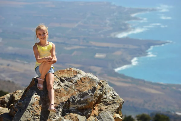 Mooi meisje zittend op de hoogste rots — Stockfoto