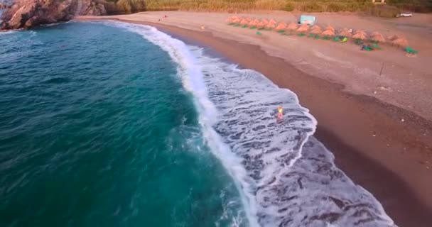 Vrouw die langs het strand loopt — Stockvideo