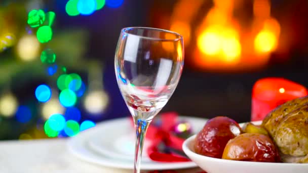 Wijn met glas gieten op kerst tafel voor open haard — Stockvideo