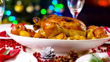 şömine ve ağaç ışıklı Noel masada kavrulmuş tavuk