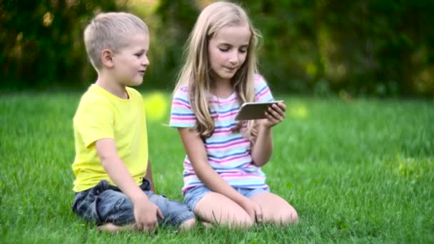 Kinder mit Smartphone draußen — Stockvideo