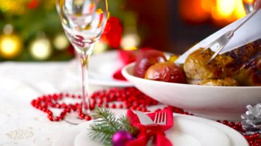 şömine ve ağaç ışıklı Noel masada kavrulmuş tavuk