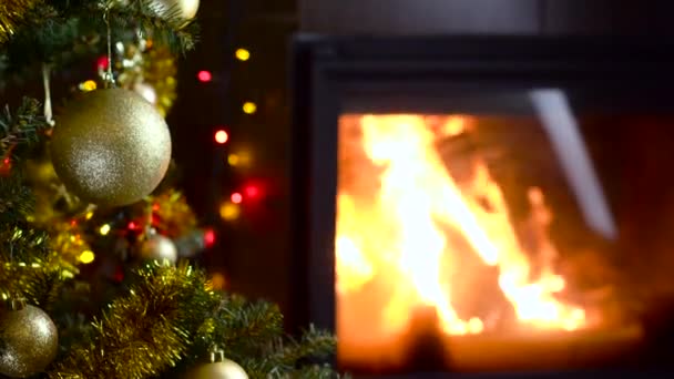 Versierd kerstboom met lampjes voor open haard — Stockvideo