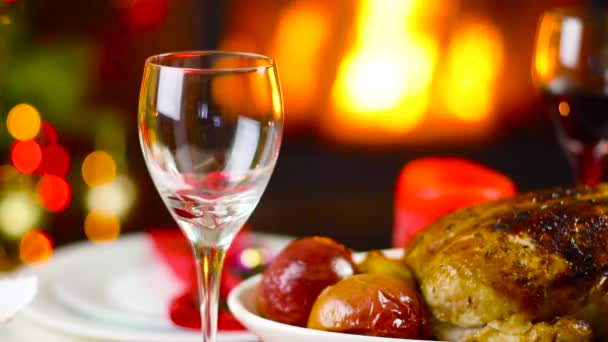 暖炉の前でクリスマスのテーブルの上のガラスに注ぐワイン — ストック動画