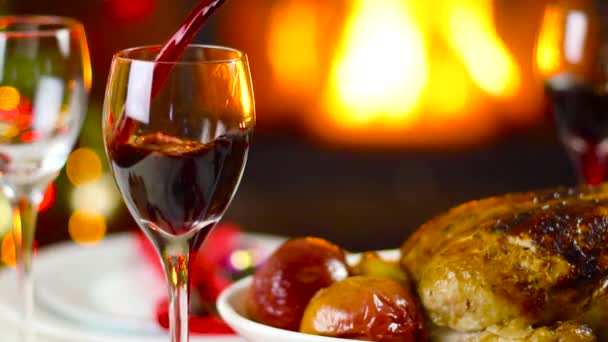 暖炉の前でクリスマスのテーブルの上のガラスに注ぐワイン — ストック動画