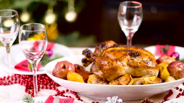 Pollo asado en la mesa de Navidad frente a la chimenea y el árbol con luces — Vídeos de Stock