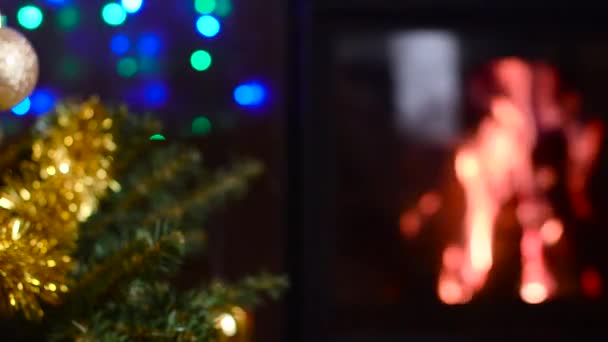 Árbol de Navidad decorado con luces delante de la chimenea — Vídeo de stock
