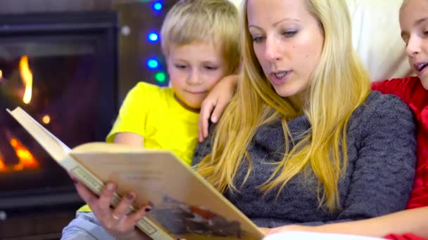 ママと子供たちの読む本でクリスマスの時間 — ストック動画