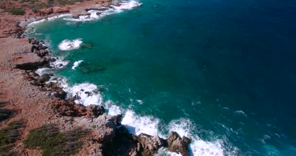 Блакитне море, хвилі ламаються в скелях на березі — стокове відео