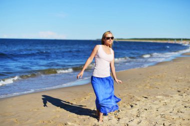 Kumsalda yürüyen bir kadın