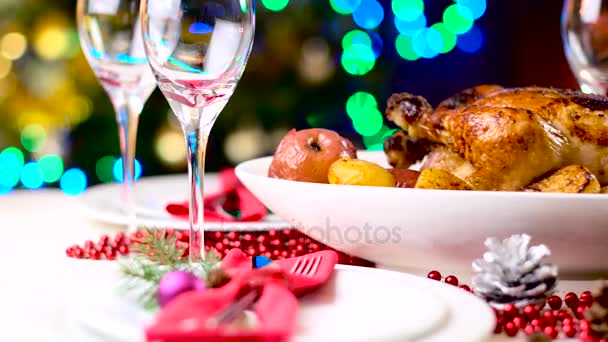 Жареная курица на рождественском столе перед камином и елкой с огнями — стоковое видео