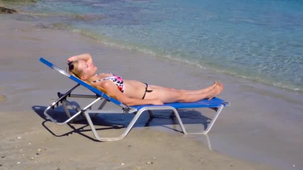 Donna sdraiata sul lettino sulla spiaggia — Video Stock