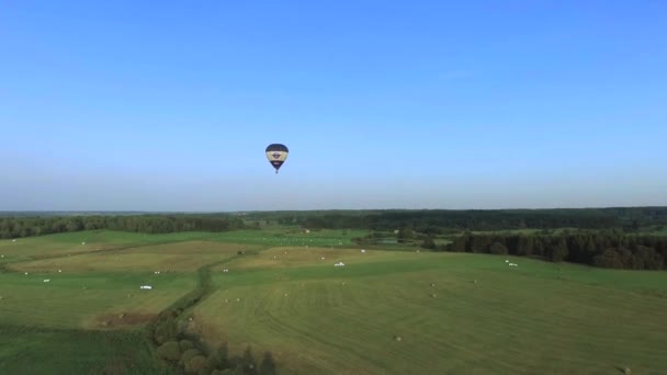 Воздушный шар над зелеными землями — стоковое видео
