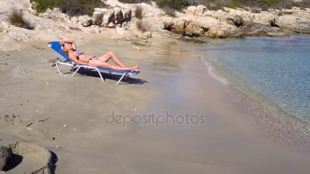 Mulher deitada no leito do sol na praia — Vídeo de Stock