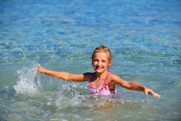 Ładna dziewczyna gra na brzegu — Zdjęcie stockowe