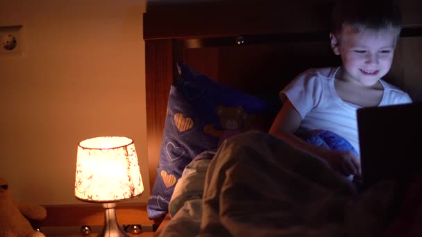 Kinderen spelen tablet in bed — Stockvideo