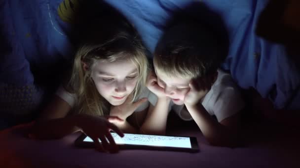 Kinderen spelen tablet in bed — Stockvideo
