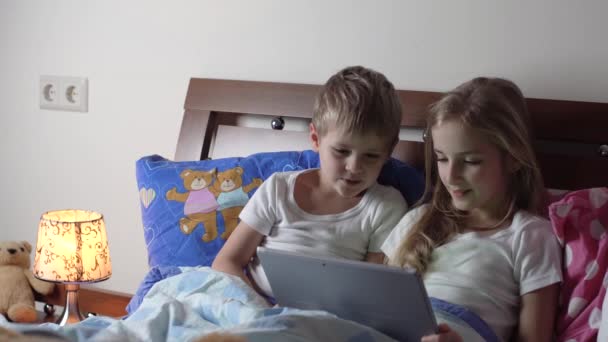 Kinder spielen Tablet im Bett — Stockvideo