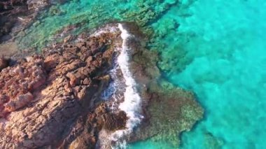 Mavi deniz, kayalıklardan sahilinde kırma dalgalar