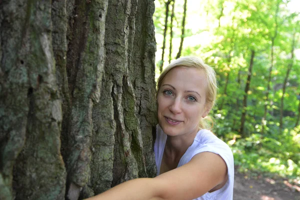 Femme étreignant tronc d'arbre — Photo