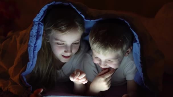 Niños jugando tableta en la cama — Vídeos de Stock