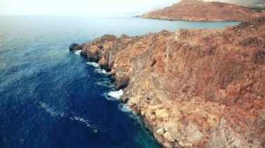 Mavi deniz, kayalıklardan sahilinde kırma dalgalar