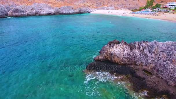 Голубое море, волны, бьющие в скалы у берега — стоковое видео