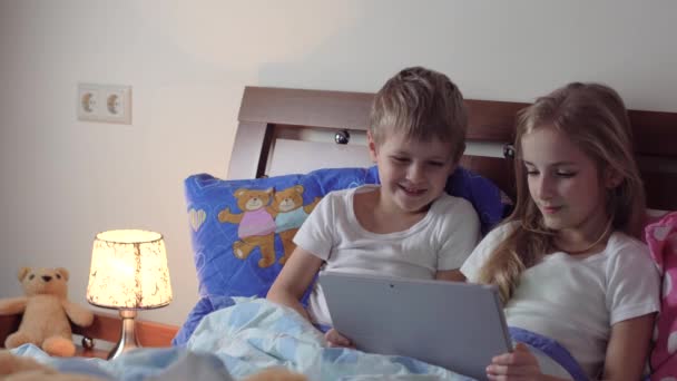 Kinder spielen Tablet im Bett — Stockvideo