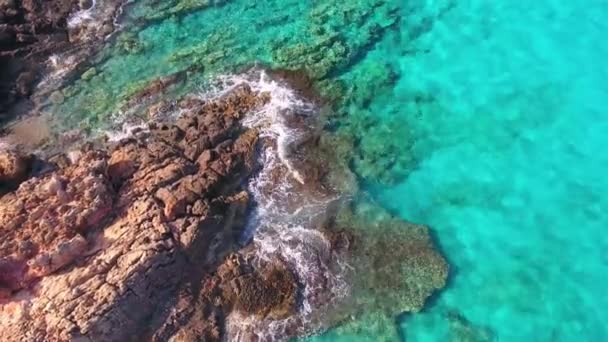 Blauwe zee, de golven breken in de kliffen aan de kust — Stockvideo