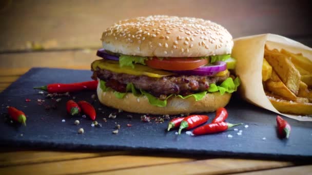 Вкусный домашний гамбургер с картошкой на каменной тарелке — стоковое видео
