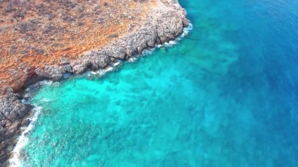 Blauwe zee, de golven breken in de kliffen aan de kust — Stockvideo