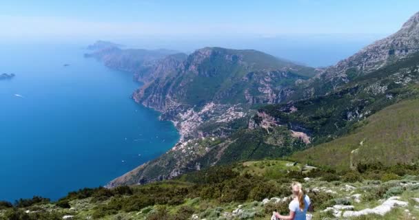 Joung mulher caminhadas em montanhas acima da costa de Amalfi — Vídeo de Stock