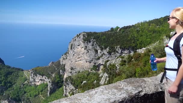 Fiatal nő túrázás hegyekben, Amalfi-part felett. Lassú mozgás — Stock videók