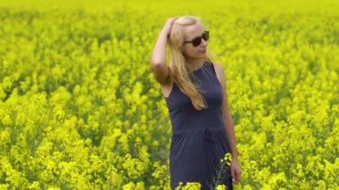 Genç sarışın kadın güzel kolza tohumu alanında poz