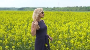 Genç sarışın kadın güzel kolza tohumu alanında poz