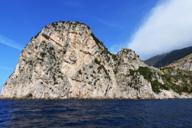 Kayalar ve deniz mavi gökyüzü altında