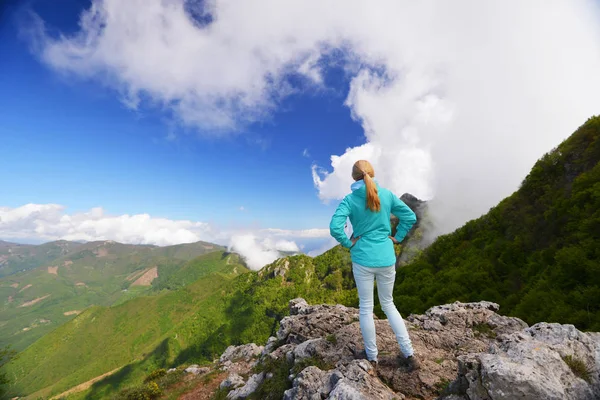 Žena stojící na vrcholu hory — Stock fotografie